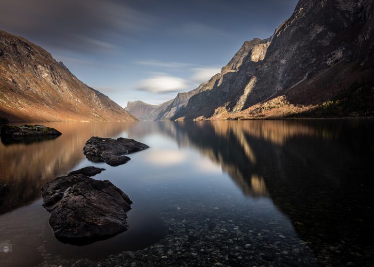 Bergsee in Norwegen im Herbstlicht mit ruhigem Wasser und sanfter Spiegelung der Berge.