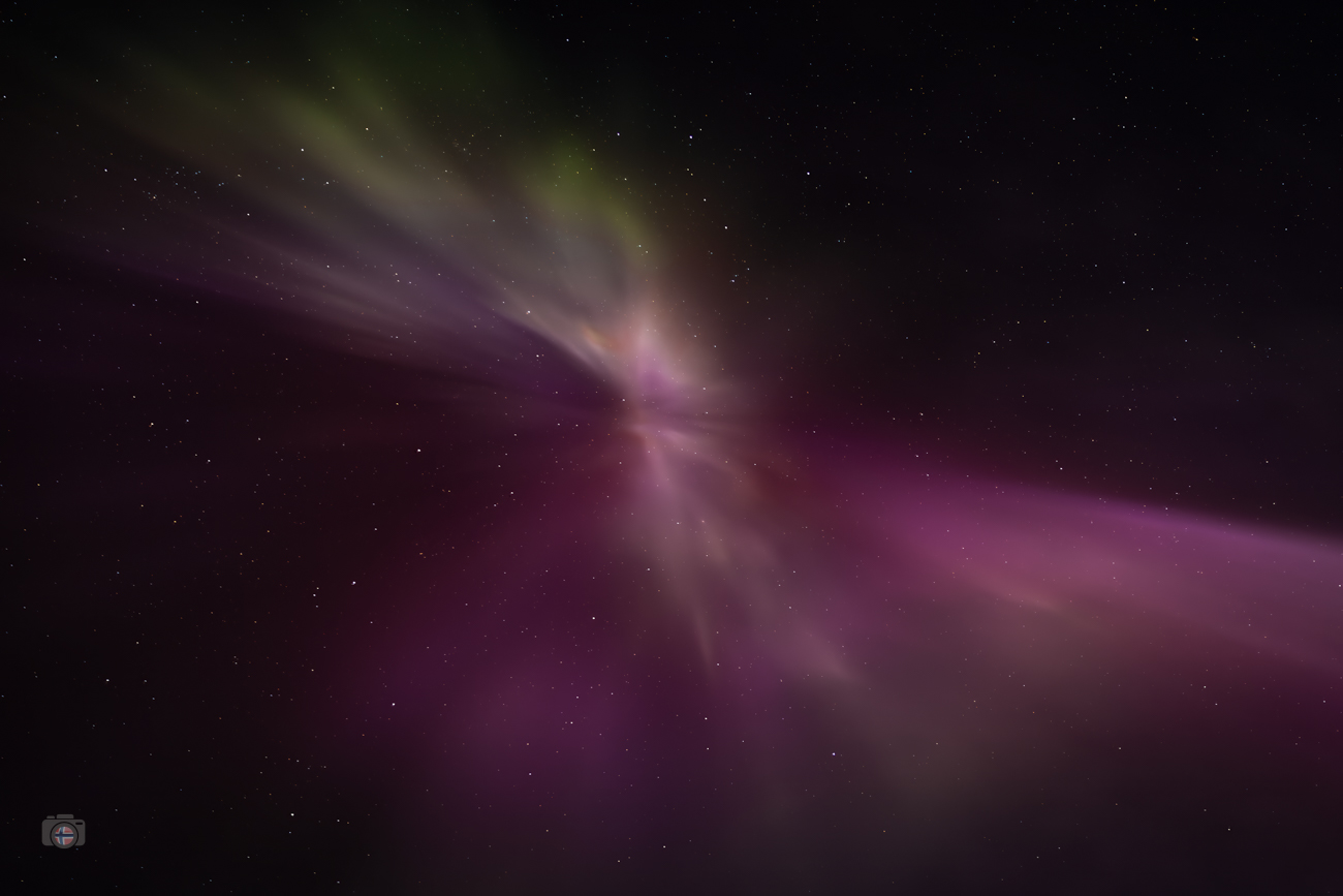 Nordlicht im Zenit direkt über dem Betrachter. Farbige Lichtbahnen aus Grün und Violett fallen wie eine Lichtdusche vom Nachthimmel herab.