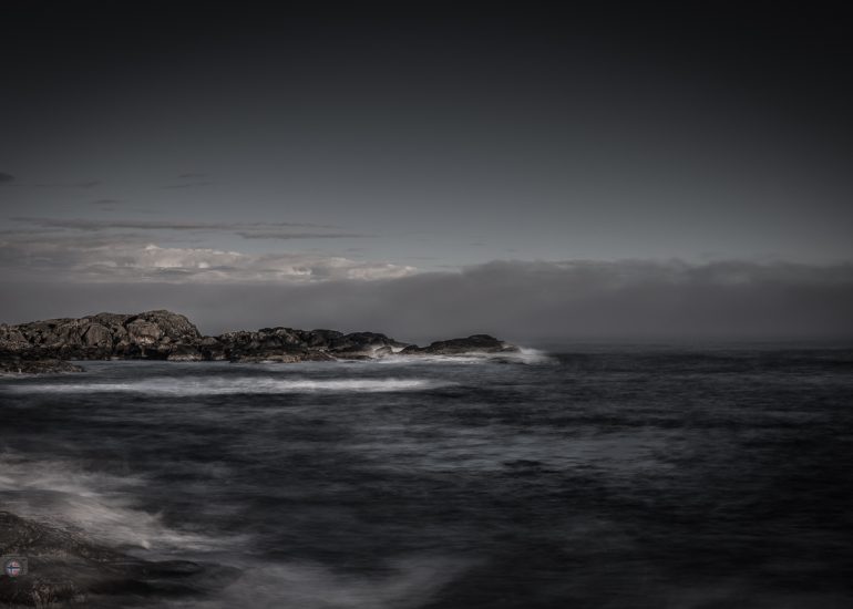Steine im Meer bei Sonnenaufgang. Weiches Winterlicht und geglättetes Wasser durch Langzeitbelichtung erzeugen eine ruhige, reduzierte Stimmung zwischen Bewegung und Stille.