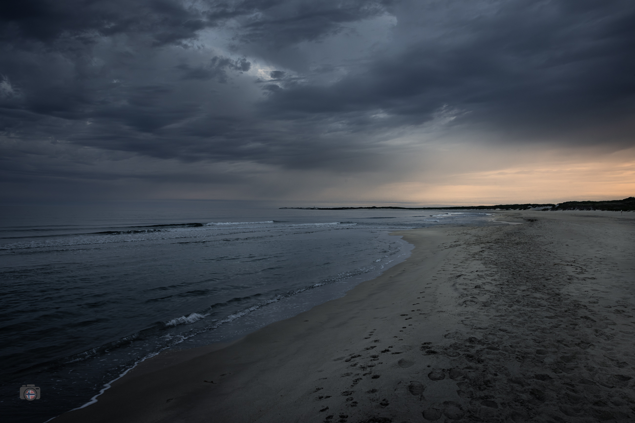 Noch liegt der Strand still und menschenleer unter dem schweren Himmel. Nur am Horizont verändert sich langsam das Licht. Dort, wo die Nacht