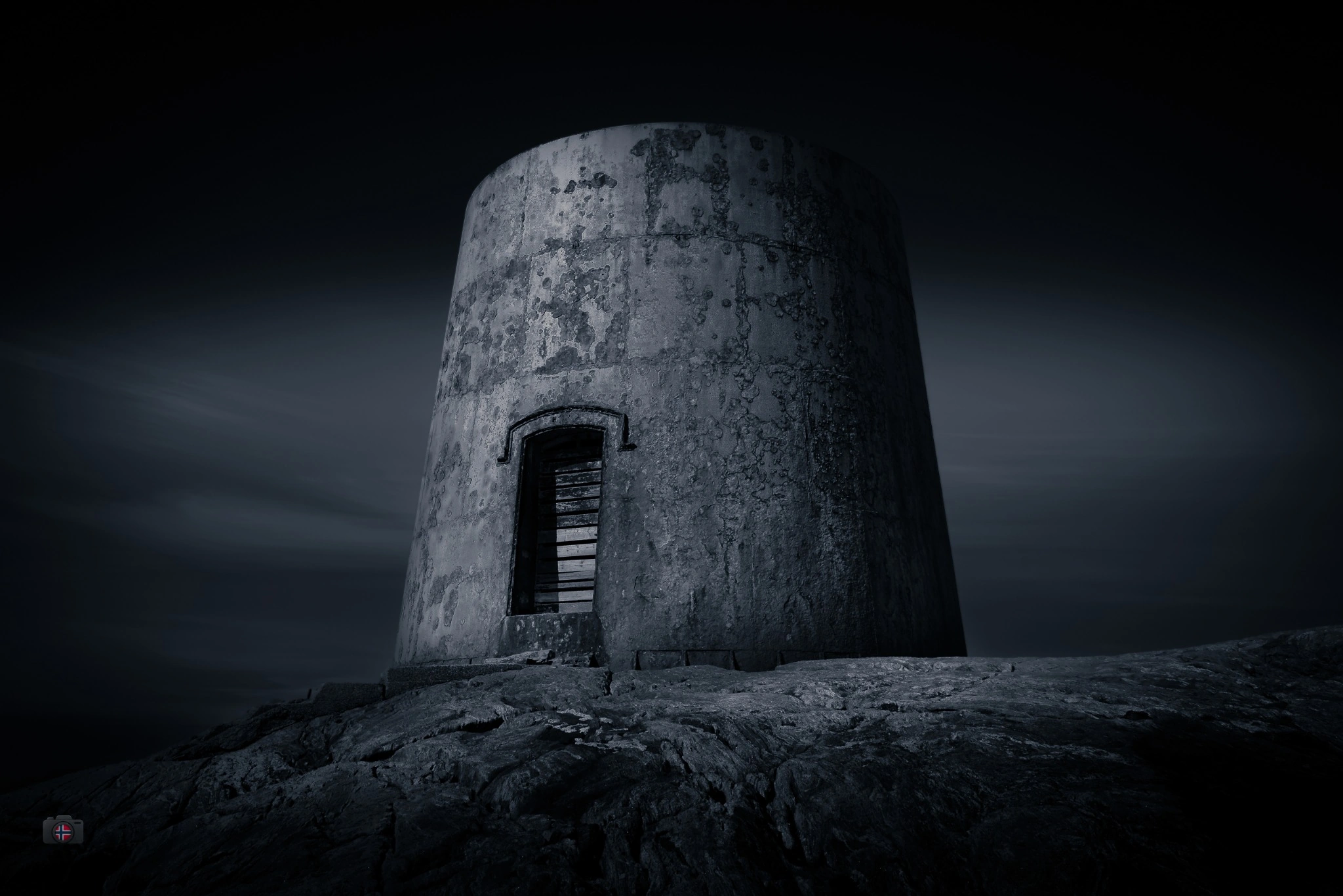 Runder alter Steinturm in einer dunklen Fine-Art-Landschaft.